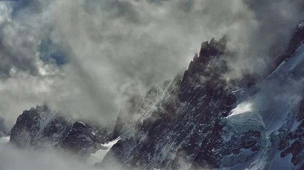 Uno Scatto Mozzafiato Una Vetta Innevata Parzialmente Coperta Nuvole Bianche — Foto Stock