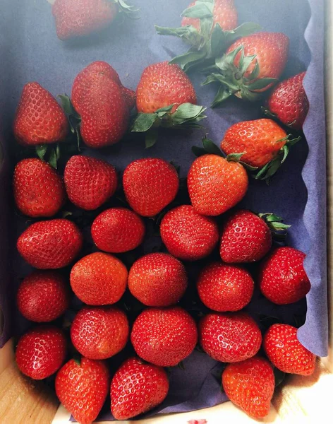 Primer plano vertical de deliciosas fresas rojas en recipientes de madera — Foto de Stock