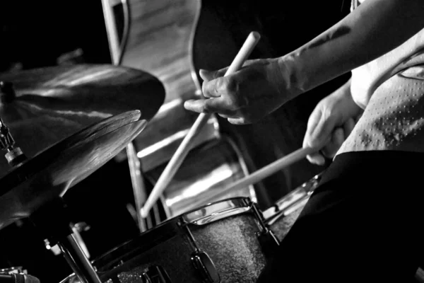 Fotografía horizontal a escala de grises de un baterista actuando en el escenario durante un concierto — Foto de Stock