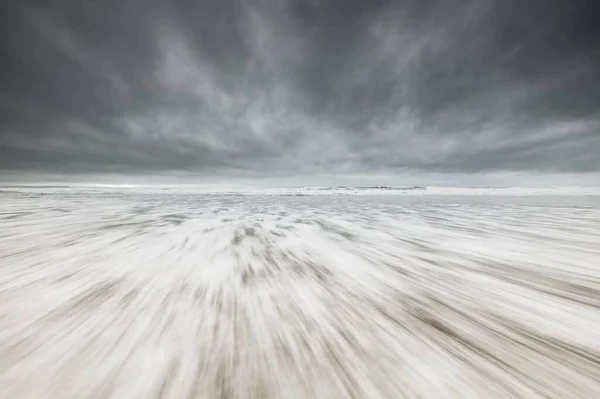 Krásný široký záběr bílého zasněženého povrchu pod šedou zamračenou oblohou. Ideální pro tapety plochy — Stock fotografie