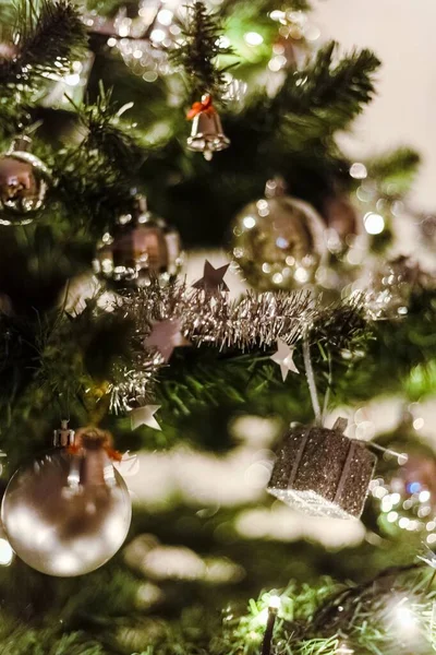 Vertical closeup shot of beautiful silver baubles and bells hanging on a Christmas tree — Stock Photo, Image