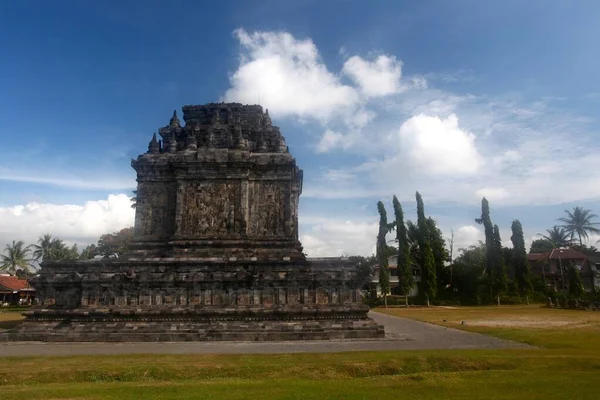 Horisontell bild av ett tempel omgivet av gröna träd på ett grönt fält i Bali, Indonesien — Stockfoto