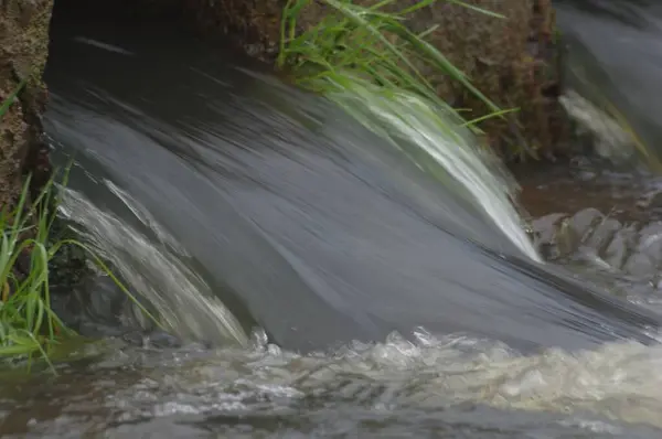Експресивний знімок сильного водоспаду, що тече в річку — стокове фото
