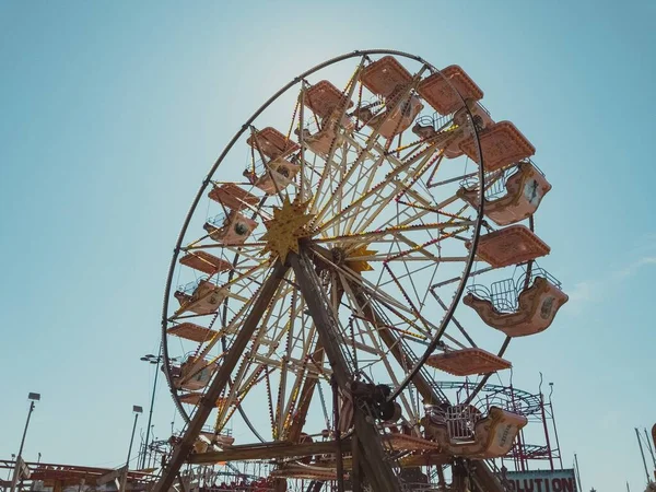 Laaghoekige opname van een reuzenrad met een blauwe lucht op de achtergrond — Stockfoto