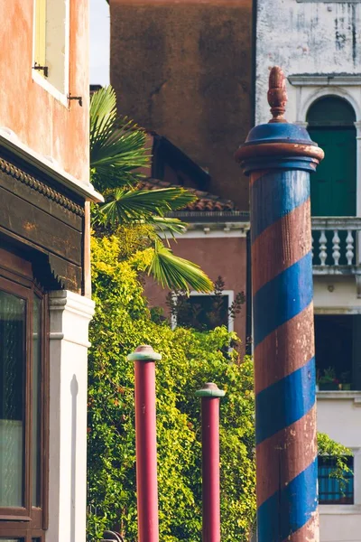 木製の柱の垂直ショットは、古いヨーロッパの都市でそれに渦巻く青い縞模様 — ストック写真