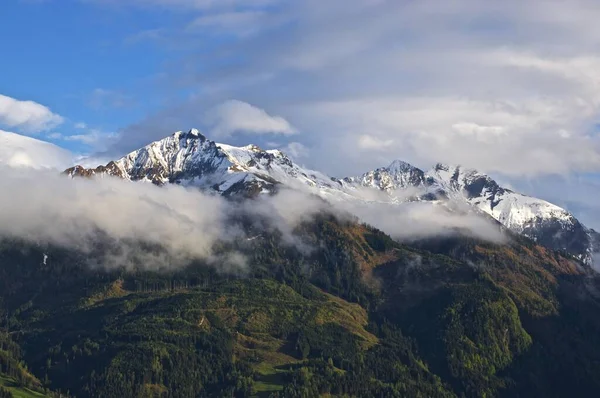 Eine Schöne Aufnahme Von Bewaldeten Bergen Mit Einem Schneebedeckten Gipfel — Stockfoto