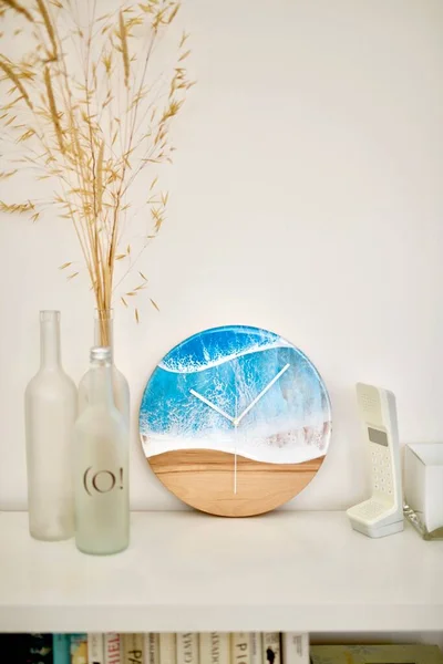 Colpo verticale di bottiglie di vetro con frumento all'interno, un orologio analogico con design marino e un telefono — Foto Stock