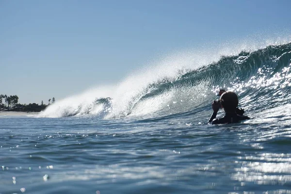 Tiro horizontal de uma pessoa na água fotografar as belas ondas durante o dia. — Fotografia de Stock