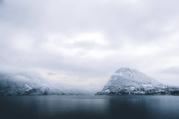 Vista deslumbrante de belas nuvens brancas cobrindo as colinas perto do lago calmo — Fotografia de Stock