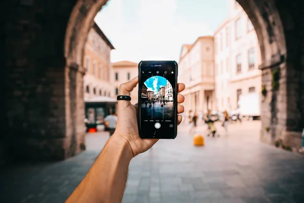 Person mit Smartphone fotografiert die schöne Aussicht mit hohen Gebäuden unter wolkenverhangenem Himmel — Stockfoto