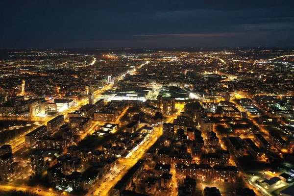 Scatto aereo di edifici con le luci accese sotto un cielo buio e nuvoloso di notte Novi Sad, Serbia — Foto Stock