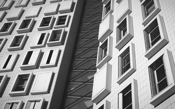 Graustufenaufnahme eines modernen weißen Gebäudes mit rechteckigen Fenstern — Stockfoto
