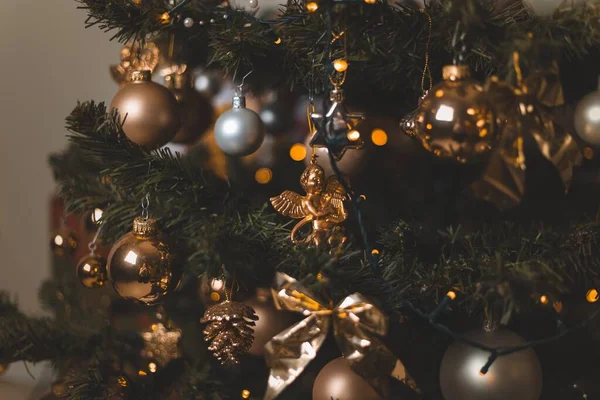 Shallow focus shot of beautiful baubles and string lights hanging on a Christmas tree — 스톡 사진