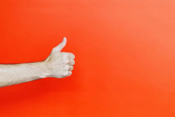 Mano de la persona que muestra un pulgar hacia arriba sobre un fondo naranja - ideal para un fondo fresco — Foto de Stock