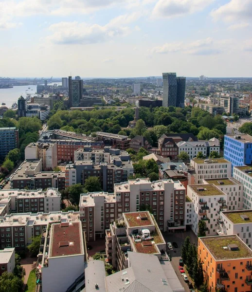 High angle shot of a lot of buildings surrounded by green trees under the cloudy sky — Φωτογραφία Αρχείου