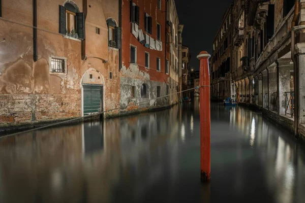 Fotografía horizontal de un canal entre los antiguos edificios de Venecia, Italia durante la noche — Foto de Stock