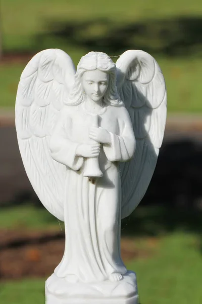 Imagen vertical de una hermosa estatua de ángulo blanco sobre un fondo borroso — Foto de Stock