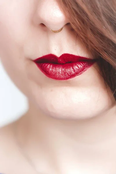 Foto de close-up vertical de uma fêmea usando batom vermelho com um leve sorriso — Fotografia de Stock