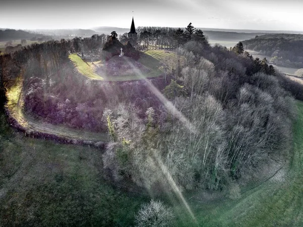 Воздушный кадр пути над холмом к зданиям, окруженным деревьями — стоковое фото