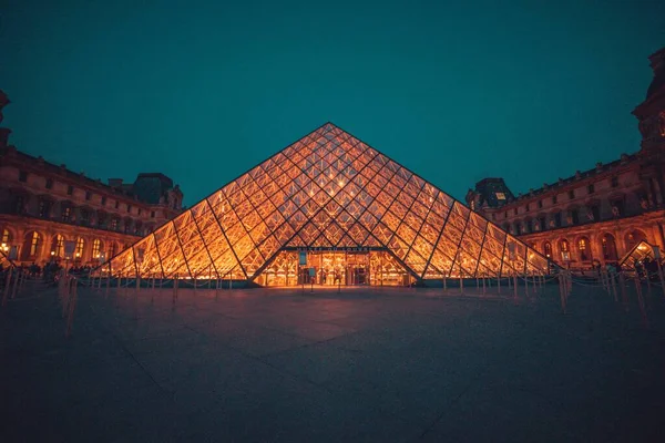 Glaspiramide van Louvre in Frankrijk 's nachts licht verspreidend voor nachtliefhebbers — Stockfoto