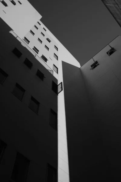 Low angle greyscale shot of high-rise buildings with a lot of windows — Stockfoto