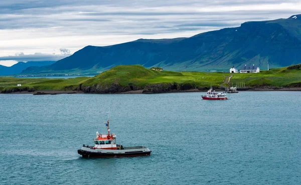 在冰岛美丽的青山环抱下 湖中的一条水平线上的小舟 — 图库照片