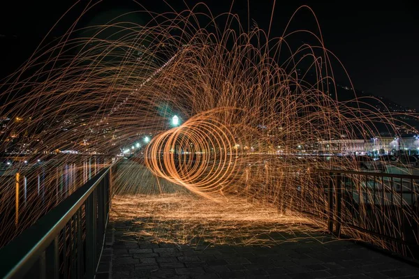 Horizontale Aufnahme von Stahlwolleeffekt auf einer Brücke mit Metallgeländern in der Nacht in Como, Italien — Stockfoto