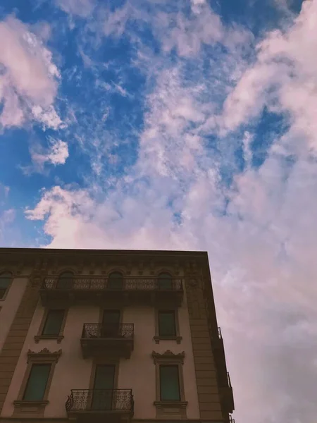 Verticale lage hoek opname van een betonnen gebouw onder de adembenemende bewolkte lucht — Stockfoto