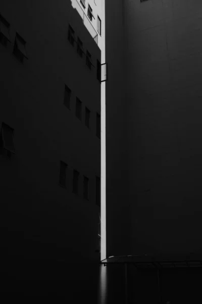 Vertikale Graustufenaufnahme weißer Gebäude mit Fenstern — Stockfoto