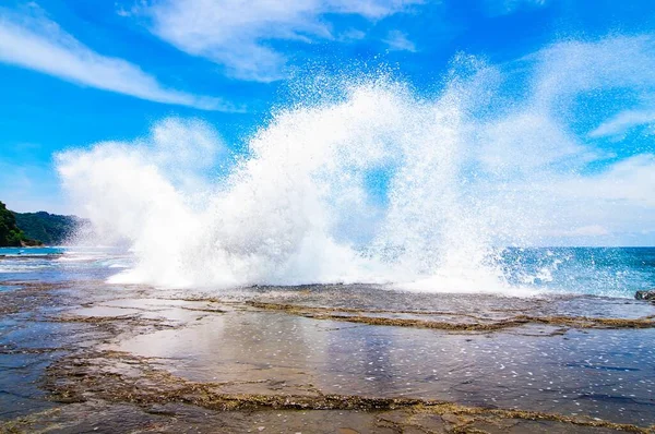 Splash dall'oceano e creando il perfetto scenario estivo sotto il cielo blu chiaro — Foto Stock
