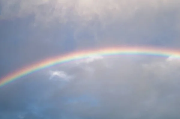 Schöne Aufnahme eines Regenbogens, der nach dem Regen am klaren Himmel herauskommt — Stockfoto