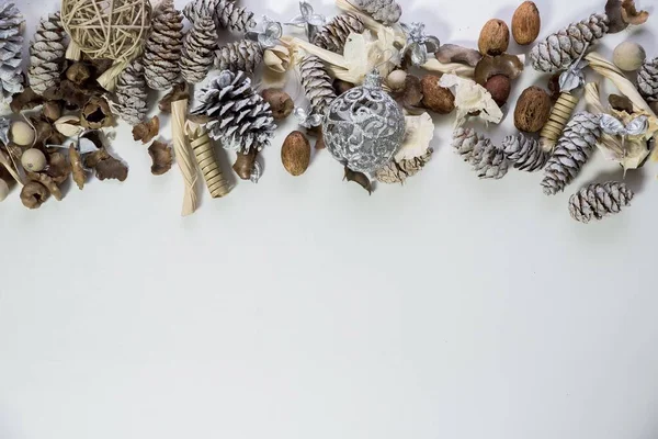 Overhead tiro de cones de pinho e ornamentos em uma superfície branca grande para escrever texto ou fundo — Fotografia de Stock