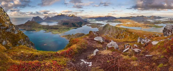 Panoramiczne ujęcie trawiastych wzgórz i gór w pobliżu wody pod błękitnym pochmurnym niebem w Norwegii — Zdjęcie stockowe