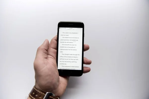 Kopfschuss eines Mannes, der die Bibel auf seinem Smartphone liest — Stockfoto