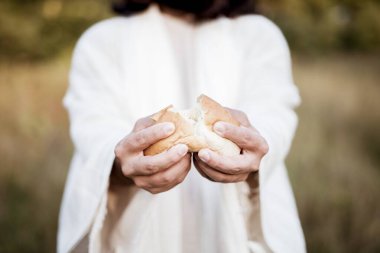 Closeup shot of Jesus Christ splitting the bread with a blurred background clipart