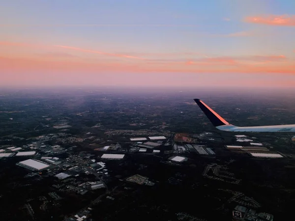 Luftaufnahme eines Flugzeugflügels mit einer wunderschönen Landschaft und dem atemberaubenden Himmel im Hintergrund — Stockfoto