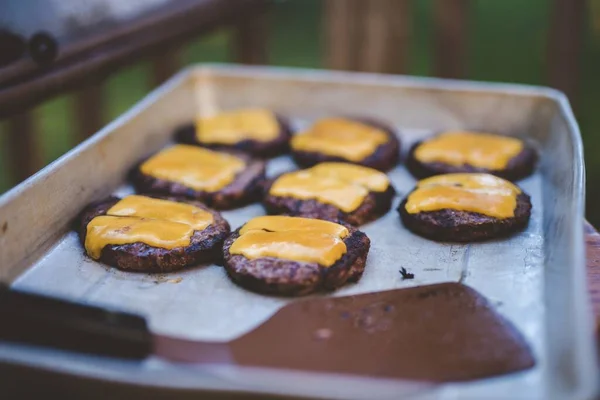 Closeup shot of beef burger on the tray with melted cheese on top — Stock Photo, Image