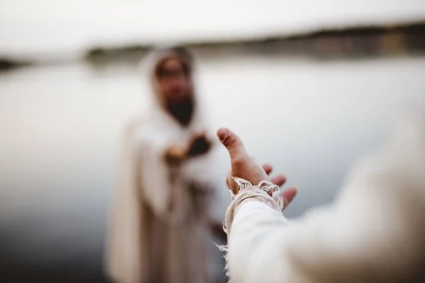 Biblical scene - of Jesus Christ lending a hand to a female with a blurred background — Stock Photo, Image