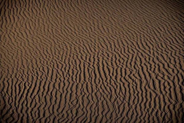 Высокоугольный снимок дюны пустыни с текстурами песчаных следов — стоковое фото