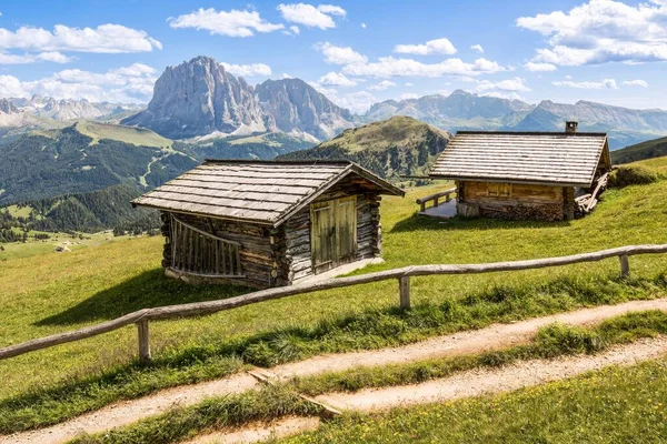 Opname van twee houten hutten op een weiland met de bergen op de achtergrond — Stockfoto