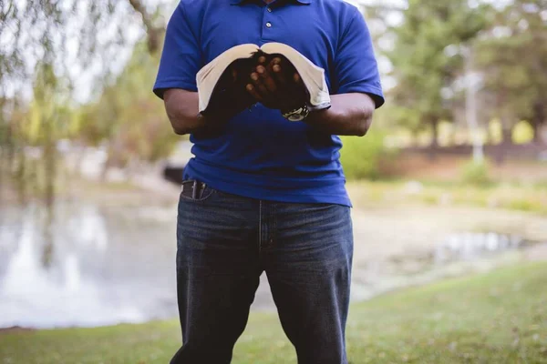 Αρσενικό στέκεται και διαβάζοντας τη Βίβλο με ένα θολό φόντο — Φωτογραφία Αρχείου