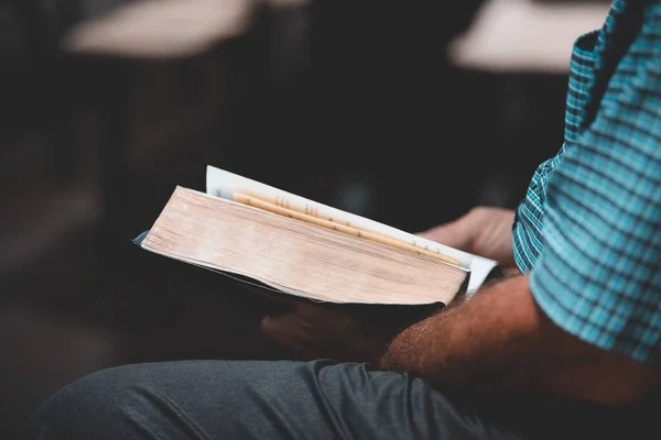 Primer plano de una persona leyendo un libro con un fondo borroso — Foto de Stock