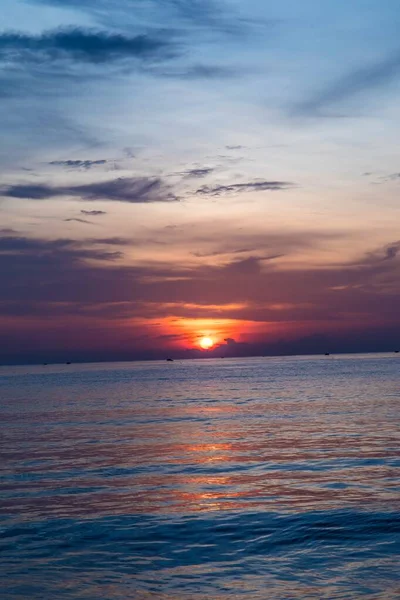 Schöne vertikale Aufnahme des Sonnenuntergangs, die sich im Meer widerspiegelt und eine atemberaubende Landschaft schafft — Stockfoto