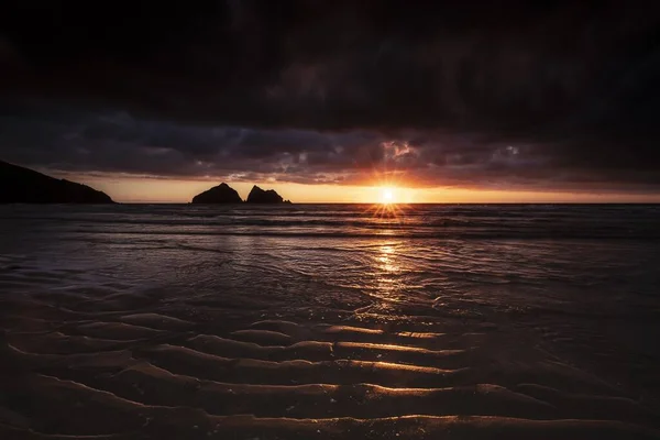 Zapierający dech w piersiach wschód słońca nad spokojnym oceanem w zatoce Holywell, Kornwalii, Uk — Zdjęcie stockowe