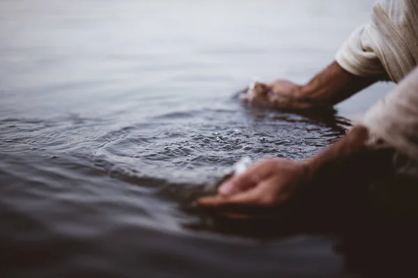 Närbild bild bild av en person som bär en biblisk mantel tvätta händerna i vattnet — Stockfoto