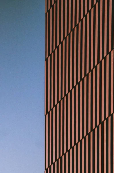 Κάθετη λήψη κτιρίου με κόκκινες και μαύρες γραμμές με φόντο τον ουρανό που κόβει την ανάσα — Φωτογραφία Αρχείου