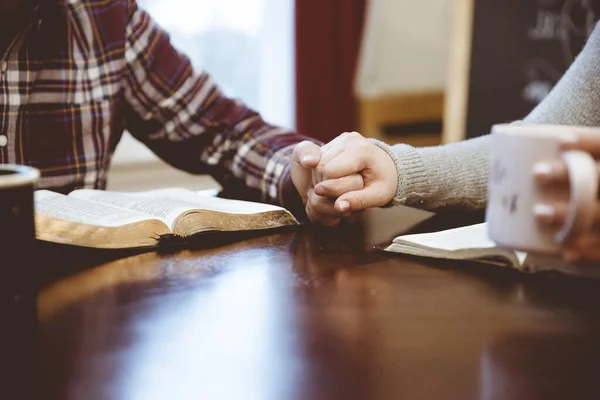 Närbild skott av ett par som håller händerna över bordet vit läsa sina böcker — Stockfoto