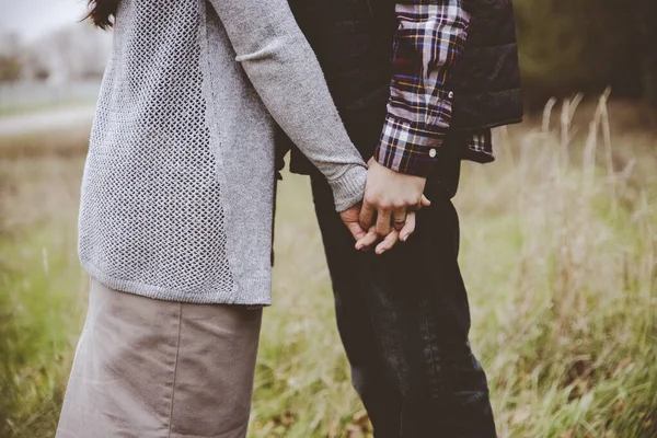 Hermosa toma de una pareja besándose mientras se toma de la mano con un fondo borroso — Foto de Stock