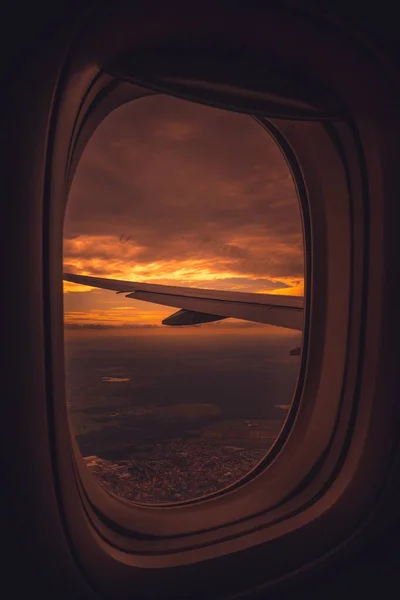 Tiro vertical de uma asa de avião a partir do interior durante um belo pôr-do-sol laranja — Fotografia de Stock