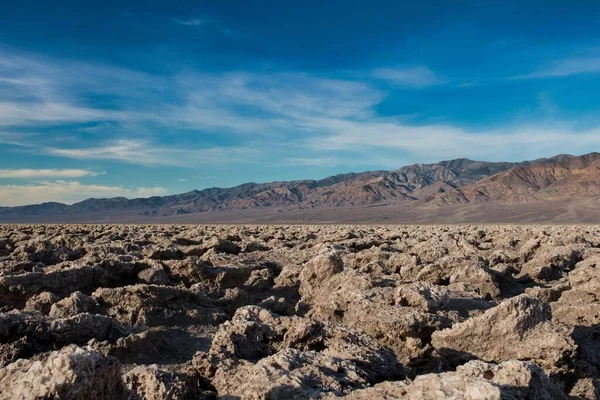 Hermosa escena de un suelo rocoso en un desierto y el cielo azul brillante en el fondo —  Fotos de Stock
